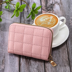 Pink quilted leather women's small card wallet with gold zipper on wooden table