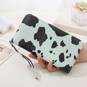 Detailed view of mint green cow print long zip wallet with matching wrist strap