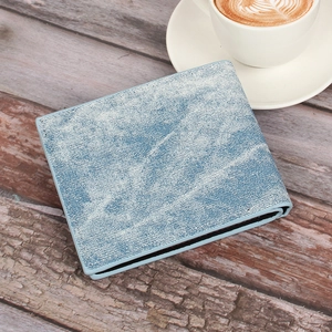 Men's denim texture bifold wallet on a wooden table with a coffee cup in a lifestyle setting