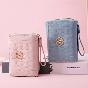 Detail of pink and blue quilted PU leather purses with golden V logo and wrist straps