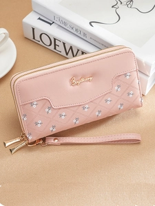 Vue détaillée du portefeuille rose gaufré à fleurs avec double fermeture éclair et dragonne