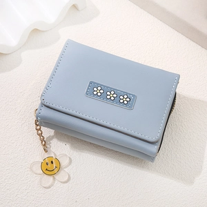 Light blue floral trifold wallet with white daisy patterns and a smiley face charm