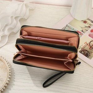 Detail of a black leather wallet showing double zipper compartments and card slots