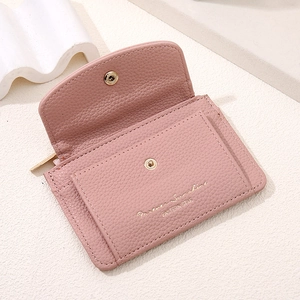 Detail of pink lychee leather card holder with snap closure and gold lettering