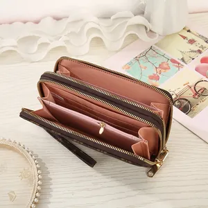 Detail view of brown vintage monogram wallet with double zippers and pink card slots