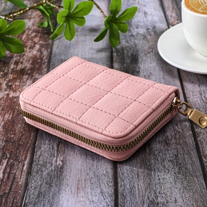 Detail of pink quilted PU leather wallet with grid stitching and gold zipper closure