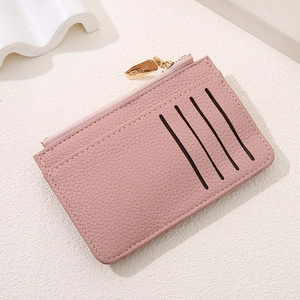 Detail of pink lychee leather card holder with four slots and a gold zipper closure