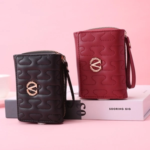 Detail of wave quilted faux leather mini wallets with golden logo and wrist strap
