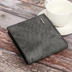 Close-up of grey denim texture and metal logo detail on a men's bi-fold wallet