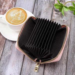 Detailed interior of a pink leather card holder with black accordion style slots
