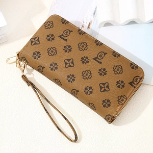 Detail view of vintage tan long wallet with floral monogram and gold zipper puller