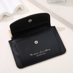 Detail of black pebbled leather wallet showing metal snap closure and side zipper pocket