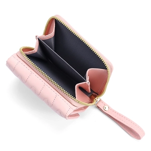 Detail view of pink trifold wallet with wavy stitching and golden zipper closure