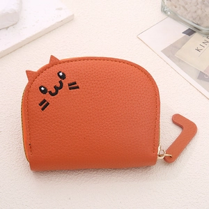 Detail of orange cat-shaped wallet with litchi grain leather and embroidered facial details