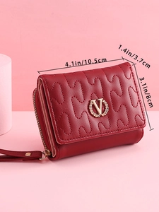 Detailed side view of a red quilted mini wallet with golden logo and wrist strap
