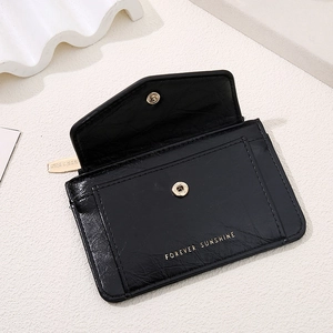 Detail of black leather wallet with Forever Sunshine gold lettering and magnetic snap button