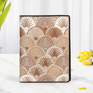 Elegant beige and gold shell patterned women's short wallet on a marble tabletop
