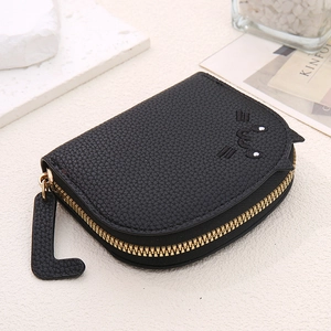 Close-up of black cat-themed mini coin purse with litchi texture and golden L zipper