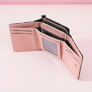 Detailed view of women's tri-fold wallet with pink interior, card slots, and zipper pocket