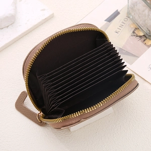 Detail of khaki leather card holder with accordion slots and gold zipper closure