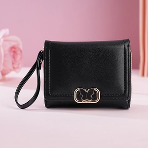 Vue détaillée du portefeuille noir en cuir avec fermoir papillon doré et lanière