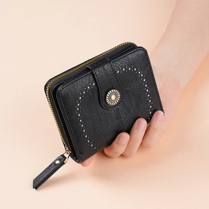 Black leather wallet with heart-shaped silver studs and a metallic sunburst decorative buckle