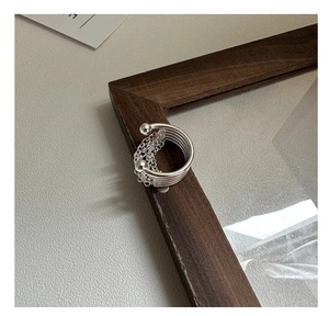 Close-up of S925 sterling silver multi-layer chain ring on a dark wooden frame corner