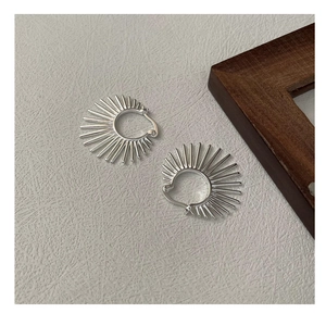 Détail de boucles d'oreilles créoles géométriques en argent en forme d'éventail