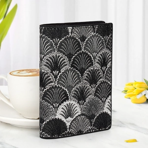 Detail of a minimalist women wallet with Art Deco fan pattern and black leather piping