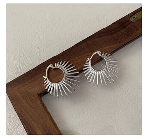 Détail de boucles d'oreilles éventail géométriques en argent S925 sur cadre en bois