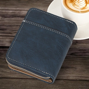 Detailed close-up of a vintage navy blue bi-fold wallet on a dark wood texture desk