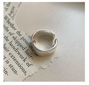 Close-up of minimalist S925 sterling silver wide ring showing the hallmark engraving