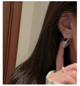 Gros plan de boucles d'oreilles géométriques en argent S925 avec une bague en perle