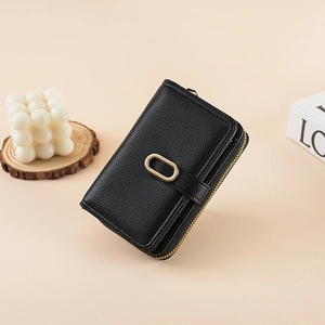 Close-up of black lychee grain leather wallet with a gold oval metal buckle and zip