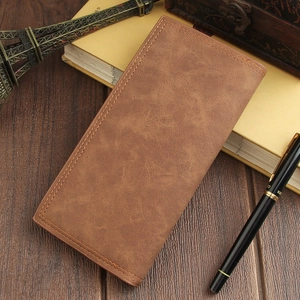 Close-up of vintage brown long leather wallet with stitching detail on wooden desk