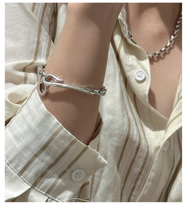 Close-up of minimalist silver chunky link bracelet and irregular wrap open bangle for women