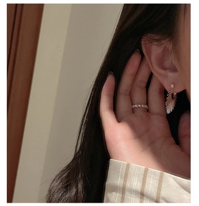 Détail de boucles d'oreilles en éventail et d'une bague perlée blanche sur mannequin