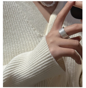 Close-up of S925 sterling silver multi-layer chain ring worn with luxury knitwear