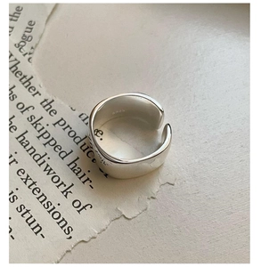 Detail view of polished S925 sterling silver wide ring band with hallmark engraving