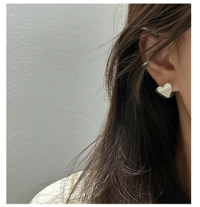 Gros plan détaillé de boucles d'oreilles cœur en argent sterling S925 à texture brossée