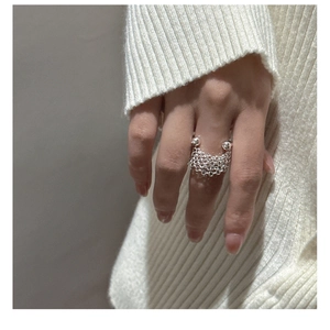 Detail of S925 sterling silver multilayer chain ring worn on a knit sweater background