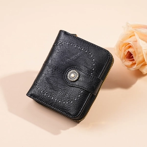 Detail of black oil-wax leather wallet with hollow carvings and retro sun-motif buckle
