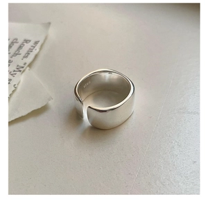 Close-up of a wide polished S925 sterling silver ring with a smooth mirror-like finish