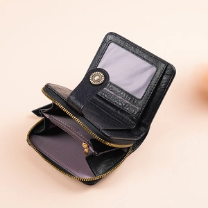 Detail of black pebbled leather wallet showing internal card slots and coin pocket