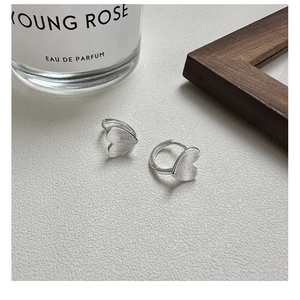 Vue détaillée des boucles d'oreilles cœur en argent S925 avec texture en métal brossé