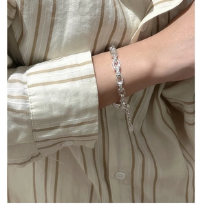 Macro detail of textured S925 sterling silver paperclip link chain bracelet on wrist