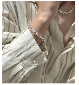 Detailed macro of S925 sterling silver paperclip chain bracelet with rectangle tag charm
