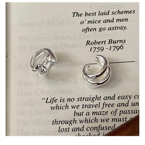 Detail view of S925 sterling silver triple-layered ear cuff on vintage book page