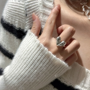 Polished S925 sterling silver heart ring worn on finger for modern minimalist look