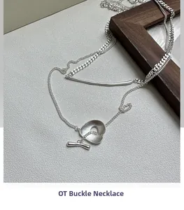 Macro shot of minimalist silver OT buckle necklace with mixed chain link textures